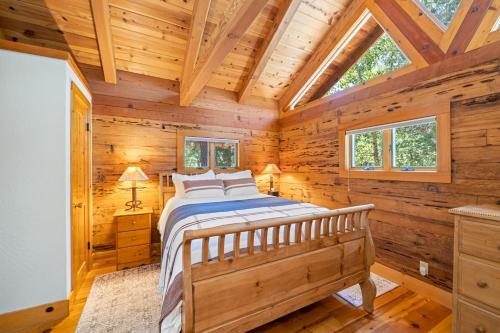 1 dormitorio con 1 cama en una cabaña de madera en River Cabins | The Lost Sierra Ranch en Graeagle