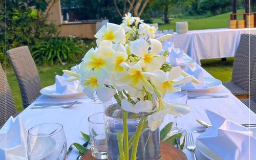 a table with a vase of white flowers on it at The Ocean Villas Managed by The Ocean Resort in Da Nang