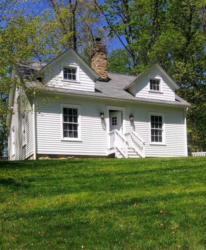 a white house on top of a green field at Historic Farmhouse by Nature Preserve in Charleston