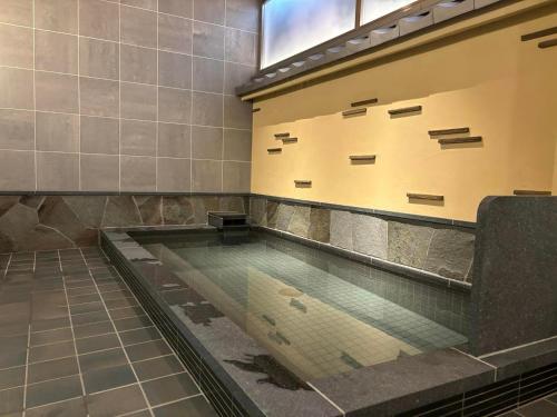 a pool of water in a room with a tile floor at Matsumoto Ryokan in Kyoto