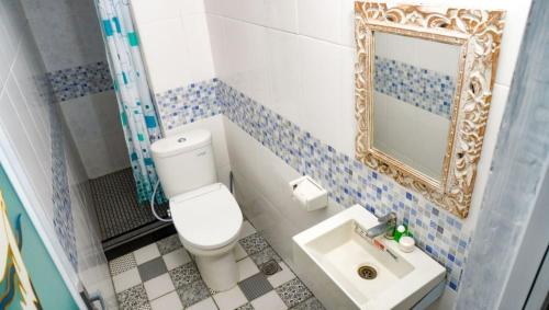 a bathroom with a toilet and a mirror and a sink at La Nusa Penida Homestay by BIJAK in Nusa Penida
