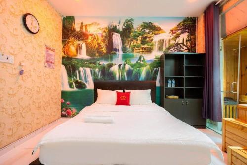 胡志明市的住宿－Hoa Hồng Hotel Ho Chi Minh City，卧室配有一张壁挂瀑布壁画的床。