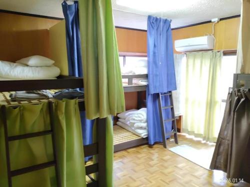 Pokój z łóżkami piętrowymi z niebieskimi i zielonymi zasłonami w obiekcie ImagineWestOcean - Vacation STAY 15914 w mieście Suo Oshima