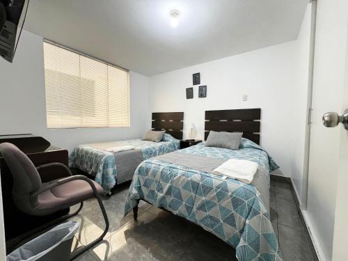 a room with two beds and a chair in it at Ayli Apart Hotel in Arequipa