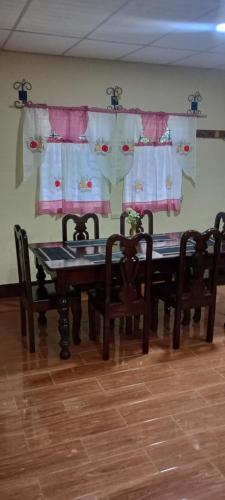 a dining room with a table and chairs and curtains at Casa Villa Flores in San Martín Zapotitlán