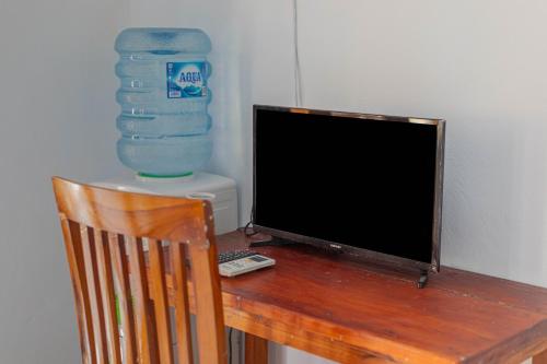 un monitor de ordenador sobre un escritorio de madera en The Salang Guest House en Nusa Penida