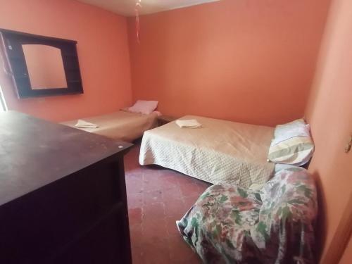 um quarto com duas camas e uma cadeira em Casas de Qlí em Santiago Atitlán