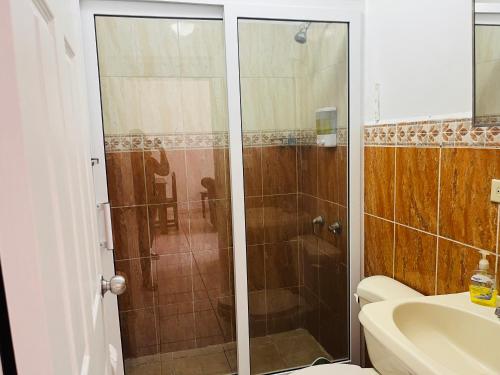 a bathroom with a shower and a toilet and a sink at WE Hotel Apartments in La Lima
