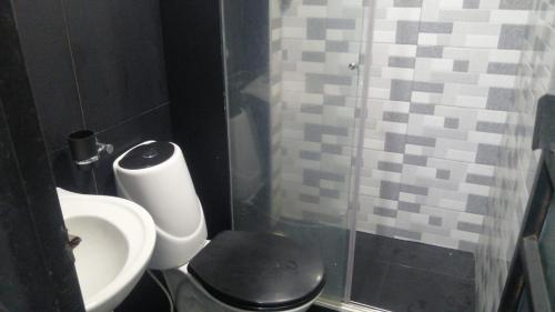 a bathroom with a toilet and a sink and a shower at Apartamento hermosa vista in Líbano