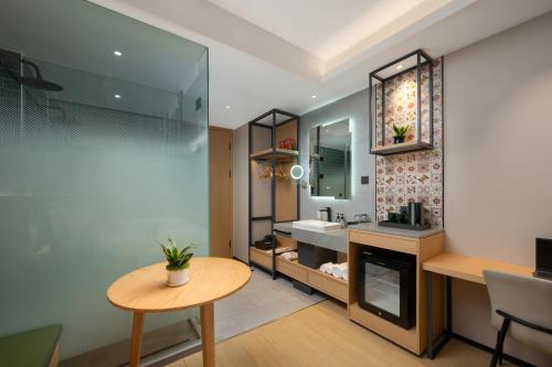 深圳的住宿－深圳福田华强北秋果酒店，浴室设有桌子、水槽和镜子