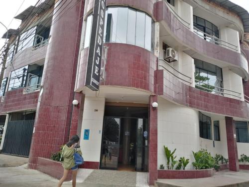 a woman walking in front of a building at Hospedaje Kennedy in Pucallpa