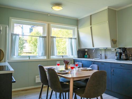 Krokstrand Fjellpark AS في Storforshei: مطبخ مع طاولة عليها كراسي ومشروبات