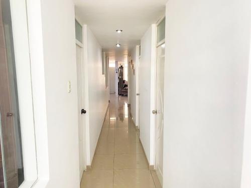 a hallway with white walls and a long white hallway at Ayli Apart Hotel in Arequipa