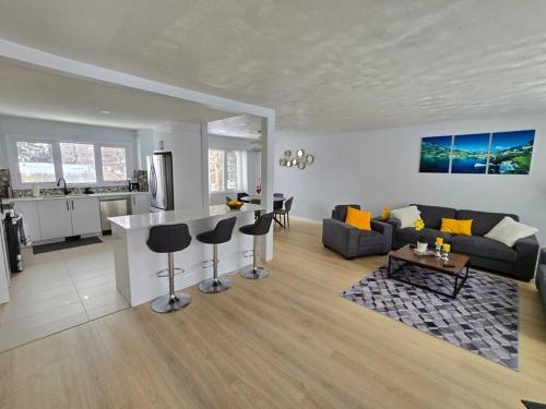 a living room and kitchen with a couch and a table at 3 Bedroom Home away from Home in Calgary
