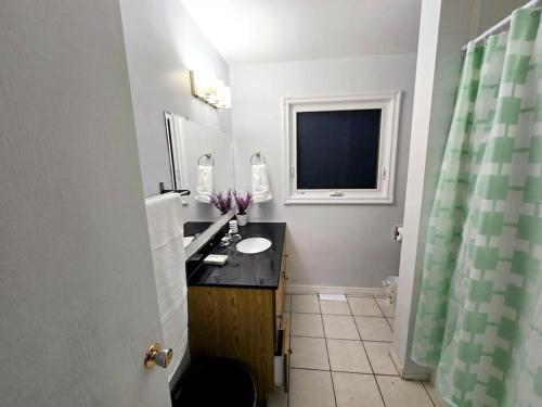 een badkamer met een wastafel en een raam bij 3 Bedroom Home away from Home in Calgary