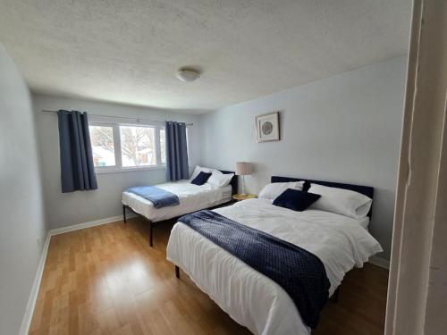 een slaapkamer met 2 bedden en een raam bij 3 Bedroom Home away from Home in Calgary
