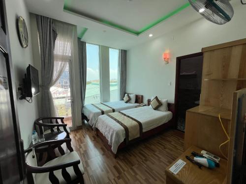 a hotel room with two beds and a television at Cát Tâm Hotel in Quy Nhon