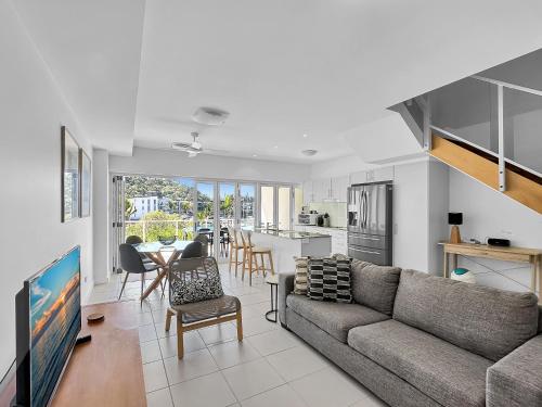 a living room with a couch and a dining room at Waterfront 'Beachside' Apartment - Ocean View, Central location, Pool, Wifi, King bed, Deluxe Spa Ensuite in Nelly Bay