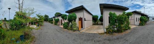 a house with a gravel road next to a building at เช็คอินรีสอร์ทชัยนาท Check-in resort in Ban Khao Khayai (1)