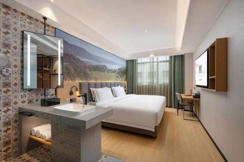 a hotel room with a bed and a sink at True Go Hotel - Shenzhen Futian Huaqiang North in Shenzhen