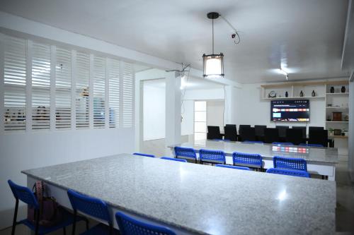 a conference room with a table and blue chairs at GRIN MCFLY INTERNATIONAL BEACHFRONT GUEST HOUSE in Fuerte