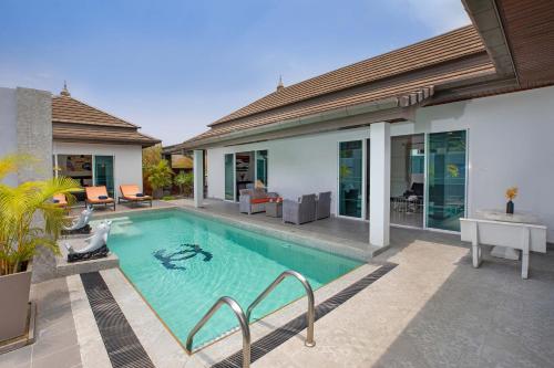 a swimming pool in the backyard of a house at 3BR Villa Marine with Private Pool, Waterfalls in NaiHarn Beach in Rawai Beach