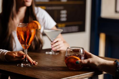 two people sitting at a table with two drinks at voco Oxford Thames by IHG in Oxford