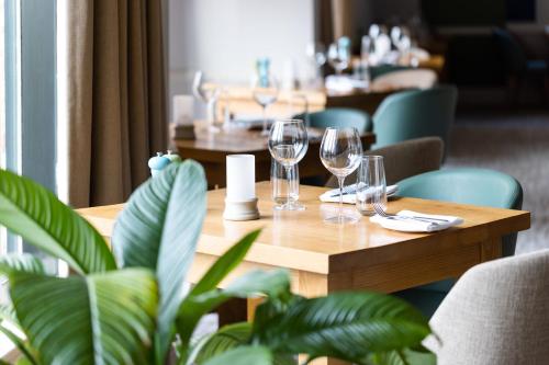 a table in a restaurant with wine glasses on it at voco Oxford Thames by IHG in Oxford