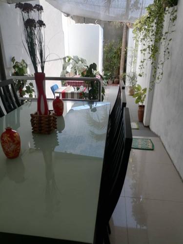 a glass table with a vase on it in a room at GRIN MCFLY INTERNATIONAL BEACHFRONT GUEST HOUSE in Fuerte