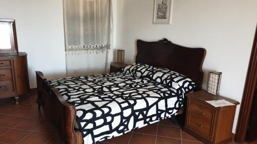 1 dormitorio con 1 cama con edredón blanco y negro en Room in Apartment - Beb apartment Pompeii Rendine, en Boscotrecase