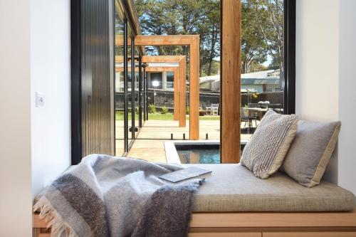 een bank met een deken voor een raam bij Elske on St Anns in Flinders