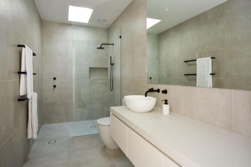 een badkamer met een wastafel, een toilet en een douche bij Elske on St Anns in Flinders