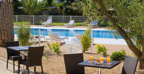 a patio with chairs and tables and a pool at Escale Oceania Nantes in Bouguenais
