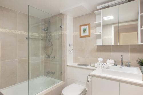 een badkamer met een douche, een toilet en een wastafel bij Beachfront Manly Apartment With Balcony & Parking in Sydney