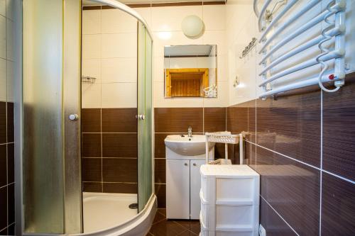 a bathroom with a shower and a sink at Ośrodek Wypoczynkowy Klif I in Gąski