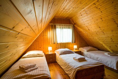 a room with two beds in a wooden cabin at Ośrodek Wypoczynkowy Klif I in Gąski