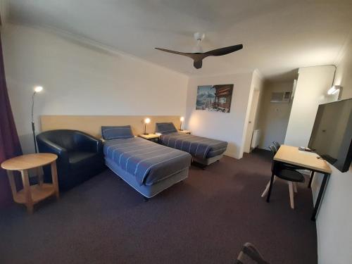 een hotelkamer met 2 bedden en een flatscreen-tv bij Cooma Motor Lodge Motel in Cooma