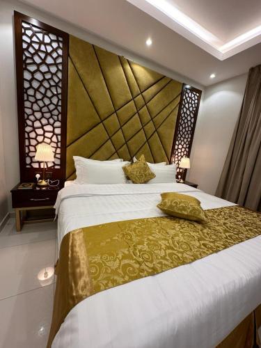 a bedroom with a large bed with a large headboard at شقق جيهان الخاصة in Al Madinah