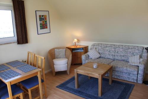 ein Wohnzimmer mit einem Sofa und einem Tisch in der Unterkunft Apartmenthaus Padua in Büsum