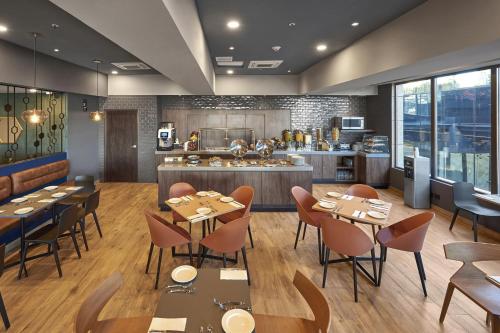 a restaurant with tables and chairs and a kitchen at City Express Plus by Marriott Ciudad de Mexico Interlomas in Mexico City