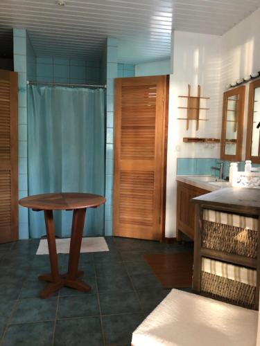 eine Küche mit einem Holztisch und einem Waschbecken in der Unterkunft Les pieds dans l’eau à huahine. Maison climatisée in Parea