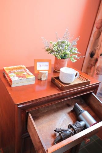 a wooden table with a cup of coffee and a book at Âm Ấm Đà Lạt Boutique Hotel & Cozy Bistro in Khu Chi Lăng