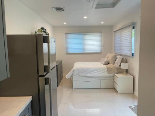 1 dormitorio con 1 cama y nevera. en Comfy studio, en Dania Beach