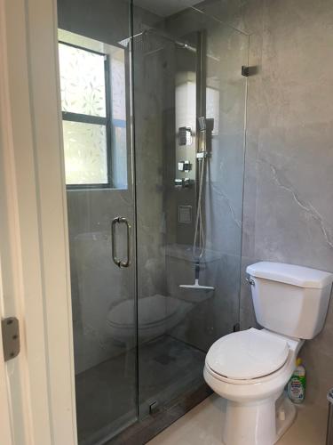 a bathroom with a glass shower with a toilet at Comfy studio in Dania Beach