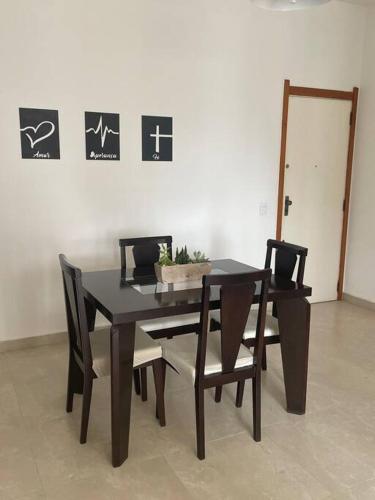 a black dining room table and chairs with a plant on it at Beachfront Condo Large Apartament in Rio de Janeiro