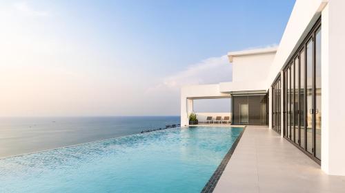 a swimming pool in front of a house with the ocean at AIR Condominium & Residence - Sihanoukville - 5mn to boat pier in Sihanoukville