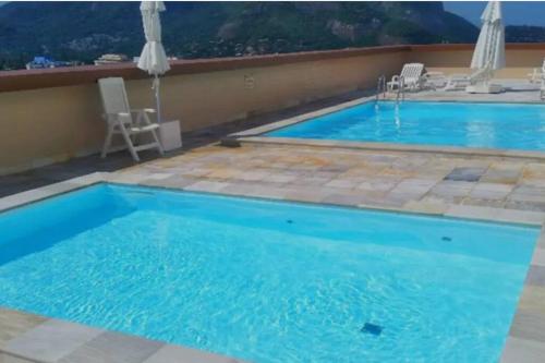 a large swimming pool with blue water at Beachfront Condo Large Apartament in Rio de Janeiro