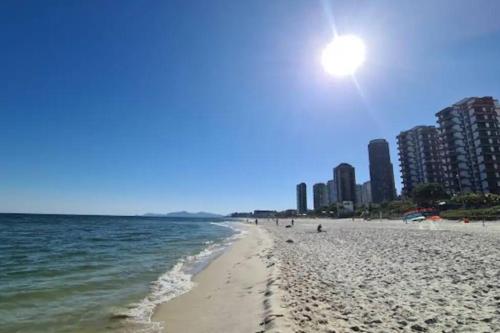 a beach with the ocean and buildings in the background at Beachfront Condo Large Apartament in Rio de Janeiro
