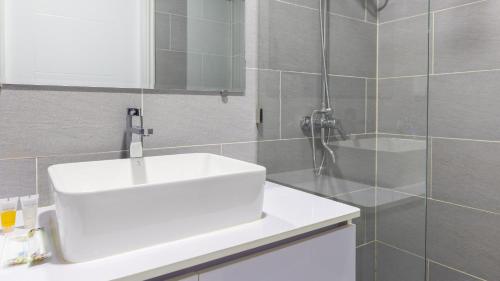 a bathroom with a white sink and a shower at AIR Condominium & Residence - Sihanoukville - 5mn to boat pier in Sihanoukville