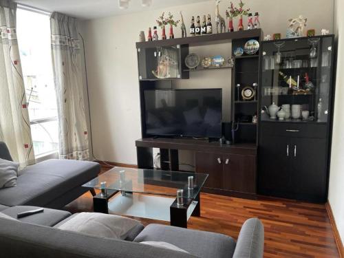 a living room with a couch and a television at Exclusivo Apartamento en el Centro de Trujillo in Trujillo
